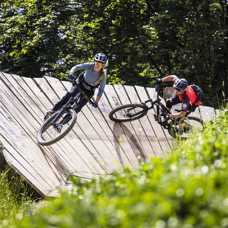 Due biker scendono lungo una parabolica nel Paganella Bike Park. | © Alex Luise, 2024