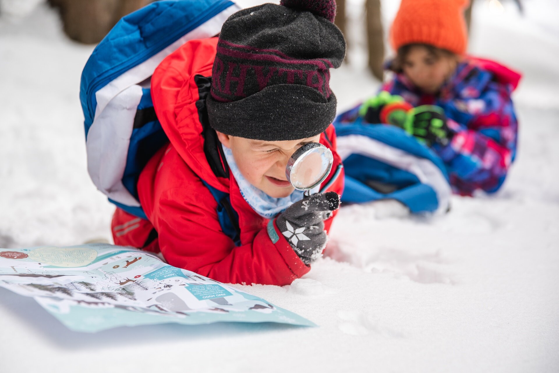 Bambini usano mappa e lente di ingrandimento per scoprire la natura innevata in Paganella. | © Oliver Astrologo, 2020