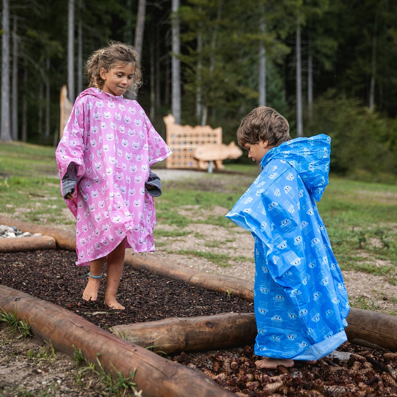 Bambini giocano sul sentiero didattico del Sarnacli Mountain Park di Andalo indossando un impermeabile per la pioggia. | © Oliver Astrologo, 2019