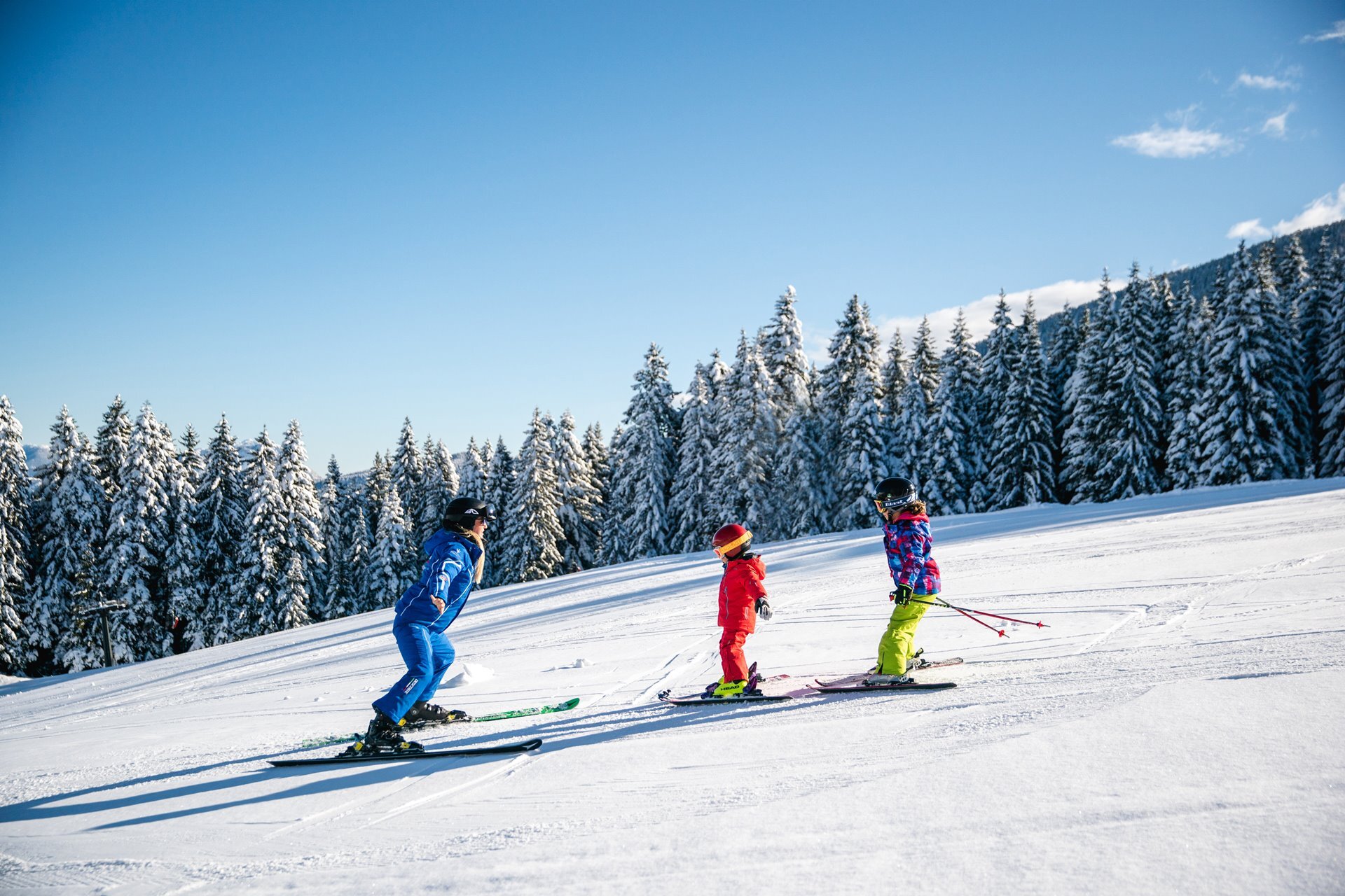 Una maestra di sci insegna le prime discese a bambini e bambine sulle piste della Paganella. | © Oliver Astrologo, 2020