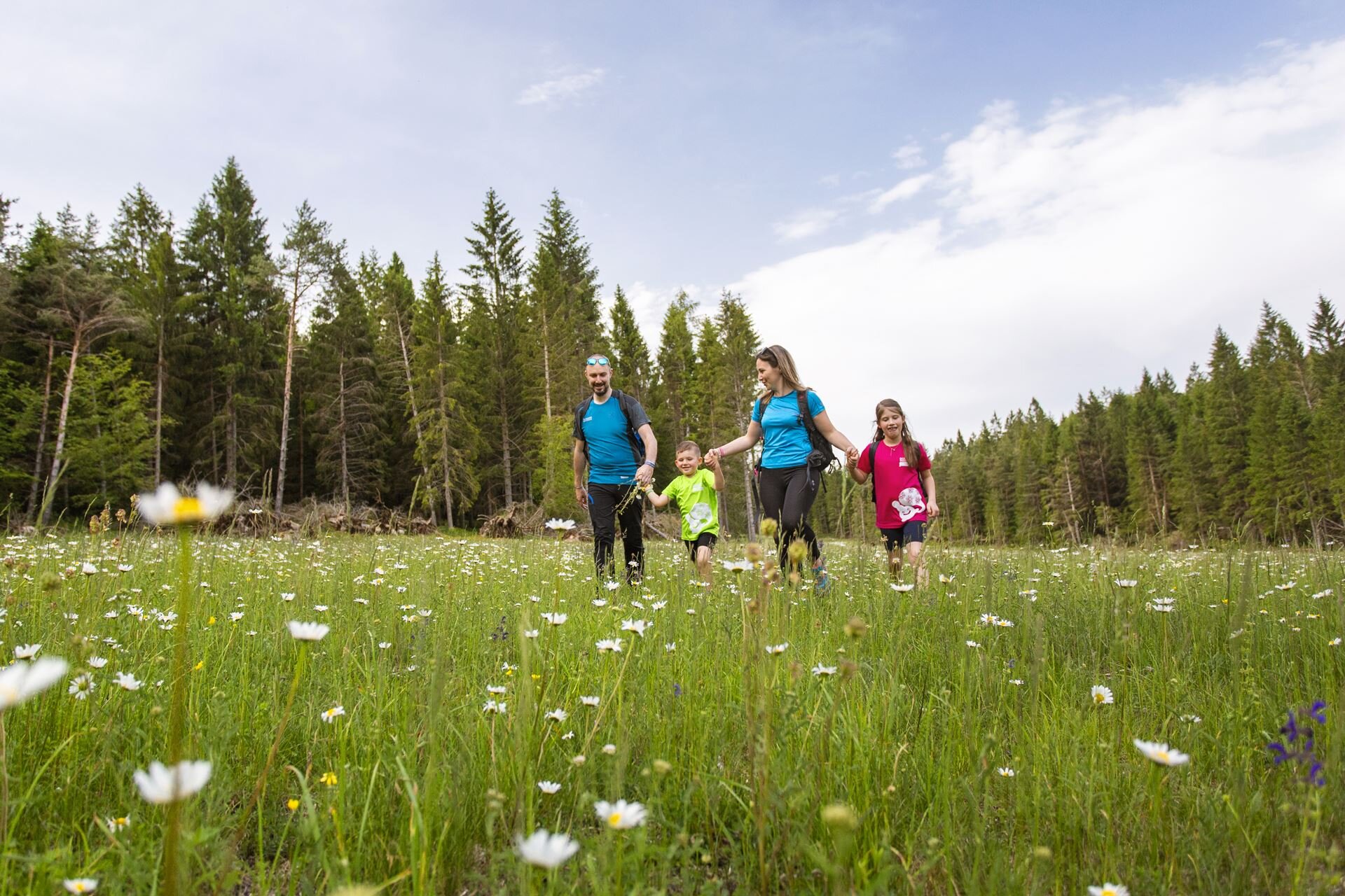 Una famiglia con bambini passeggia fra i boschi e i prati fioriti dell'altopiano della Paganella. | © Filippo Frizzera, 2019