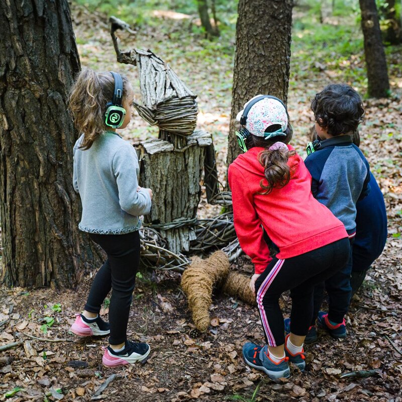 Tre bambini, di spalle, osservano un "abitante" del bosco di Fai della Paganella. | © Mirko Perli, 2023