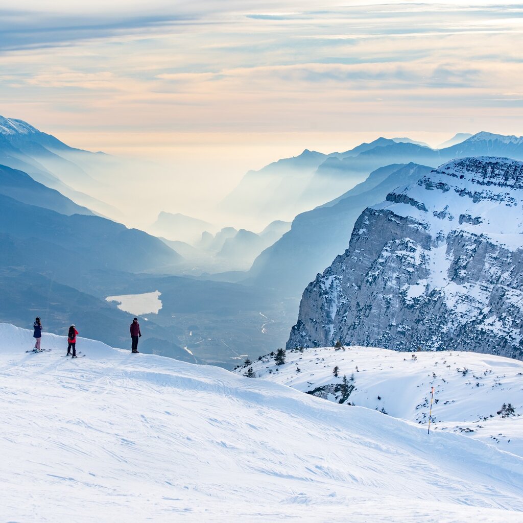 From the top of Paganella some skiers admire the view that reaches Lake Garda | © Giorgio Monticelli, 2020 From the top of Paganella some skiers admire the view that reaches Lake Garda | © Giorgio Monticelli, 2020