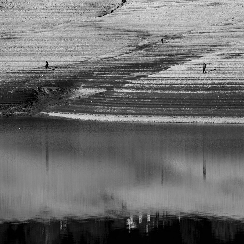 Foto in bianco e nero con persone che camminano sul lago di Molveno svuotato | © Filippo Frizzera, 2017