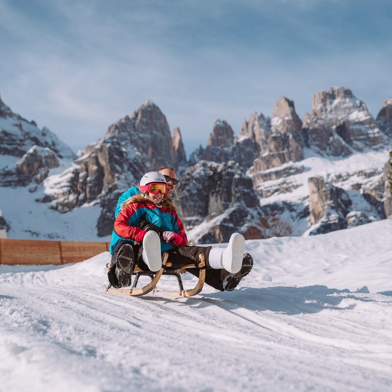 Una bambina scende con il papà sulla pista da slittino Scoiattolo sull'altopiano di Pradel. | © Alice Russolo, 2023