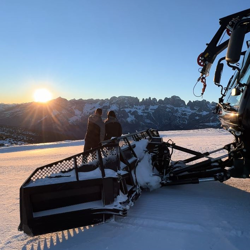 Ein junges Paar bewundert den Sonnenuntergang über den schneebedeckten Brenta-Dolomiten von den Hängen des Paganella | © Nils Astrologo, 2022