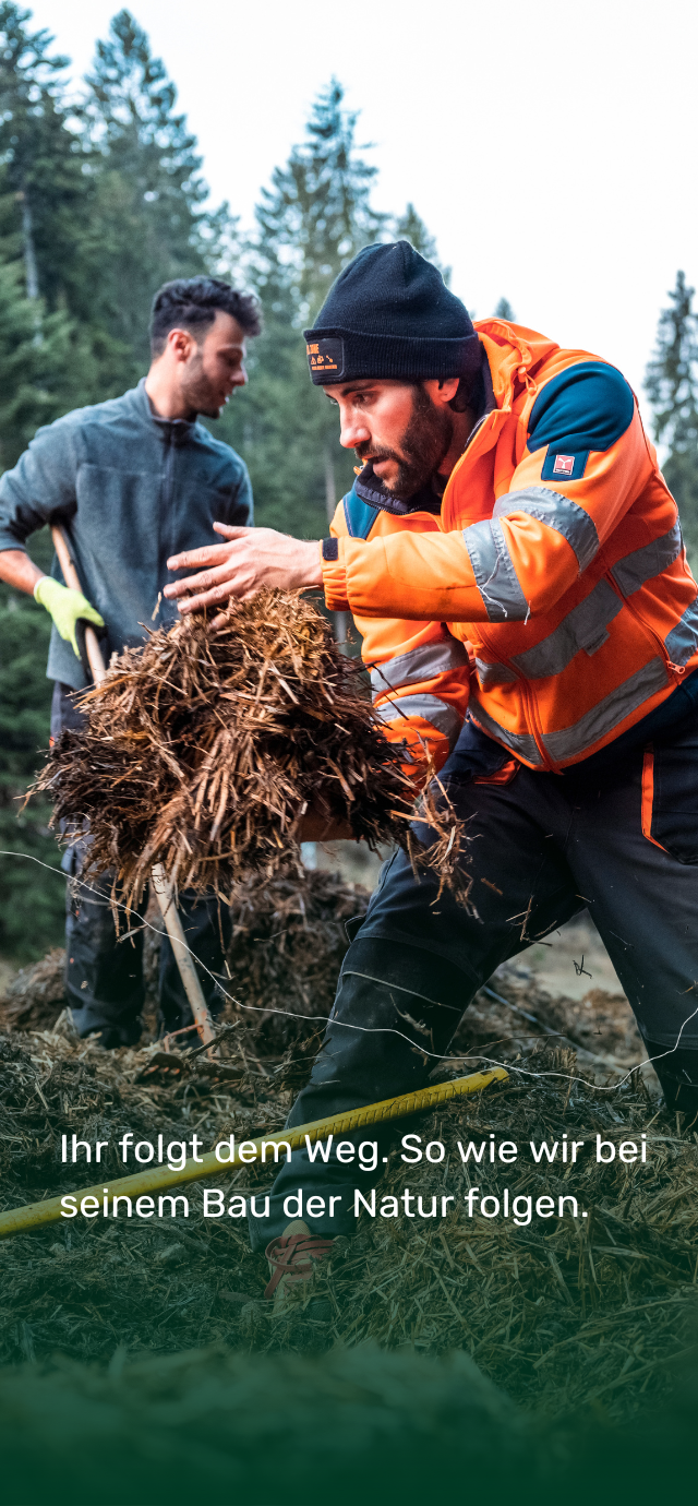 im Bild: Bauarbeiter sind damit beschäftigt, das Gestrüpp zu entfernen. im text: Ihr folgt dem Weg. So wie wir bei seinem Bau der Natur folgen. | © Frame & Work, 2024