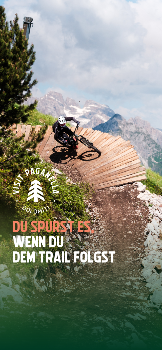 Filippo Frizzera, 2024 | © Auf dem Bild: ein Biker auf einem Wallride mit Blick auf die Brenta-Dolomiten im Hintergrund. Im Text: Du spürst es, wenn du dem Trail folgst