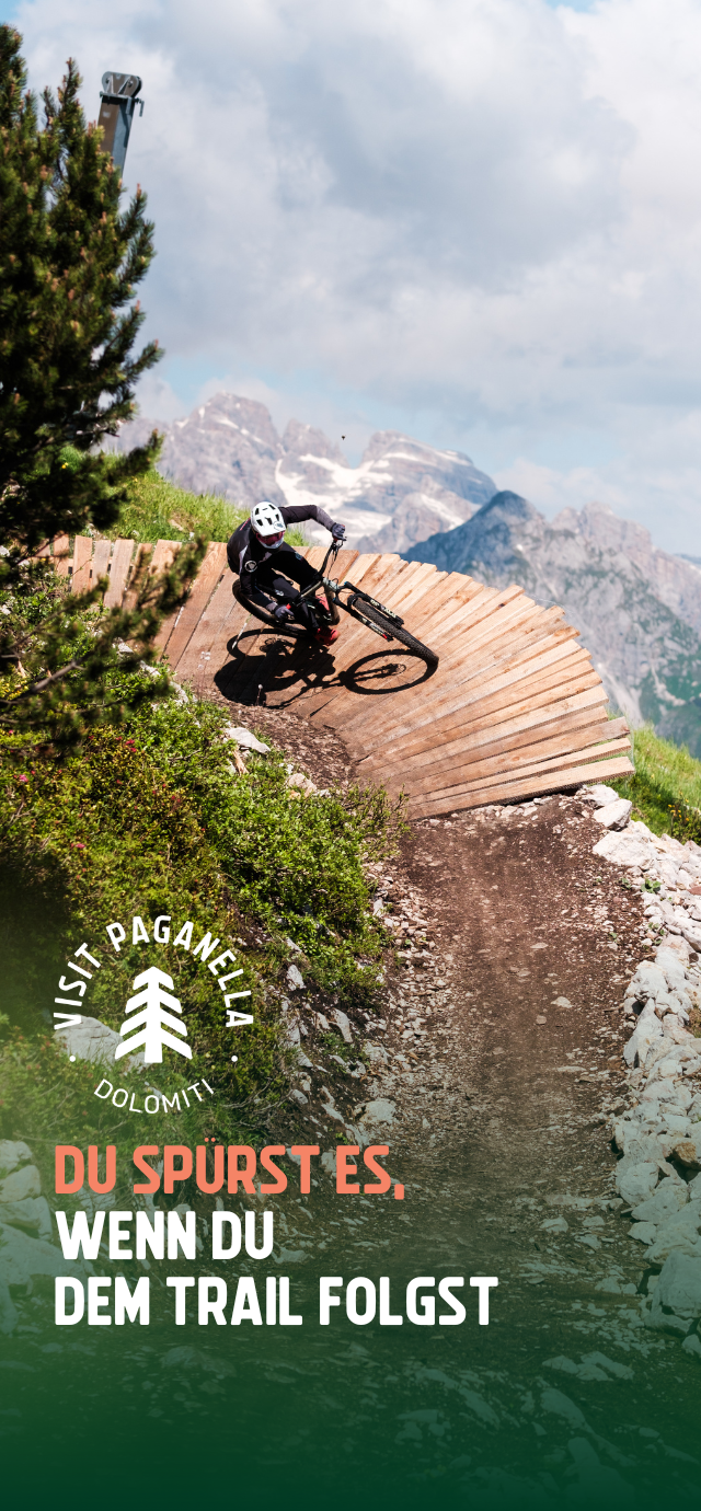 Filippo Frizzera, 2024 | © Auf dem Bild: ein Biker auf einem Wallride mit Blick auf die Brenta-Dolomiten im Hintergrund. Im Text: Du spürst es, wenn du dem Trail folgst